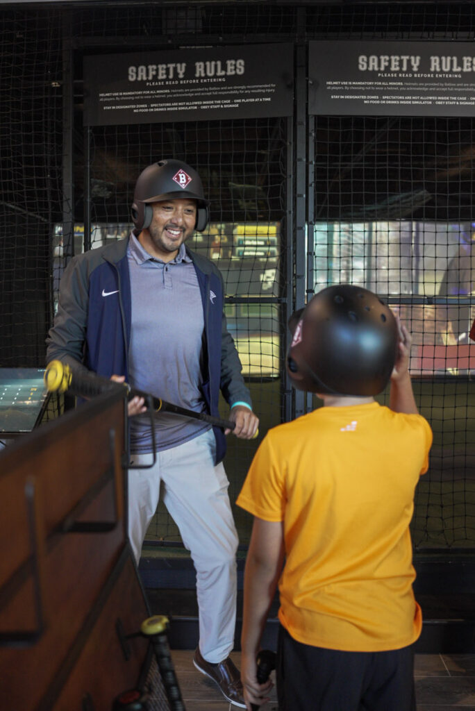 Father and son enjoying a batting cage experience together at Batbox Dallas sports venue